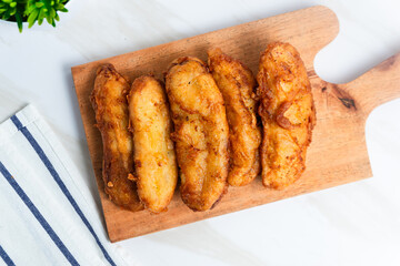 Fried Banana served on a wooden cutting board. Indonesian street food. Indonesian food. Perfect for recipe, article, catalogue, commercial, or any cooking contents.