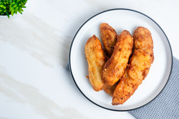 Fried Banana served on a white plate. Indonesian food. Indonesian street food. Perfect for recipe, article, catalogue, commercial, or any cooking contents.