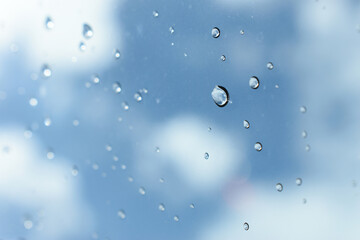 water drop on mirror with blue sky and white cloud background