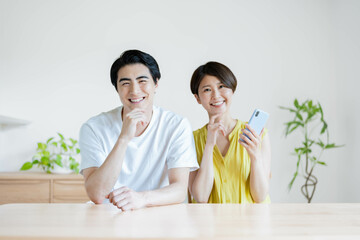 カメラ目線で笑顔の日本人夫婦・カップル