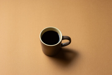 茶色の背景に置いたコーヒーカップ