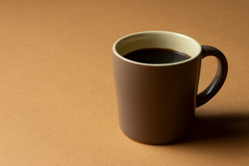 茶色の背景に置いたコーヒーカップ