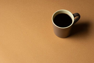 茶色の背景に置いたコーヒーカップ