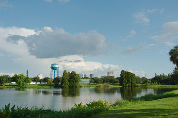Wide shot Looking  south,  over Crescent Lake park , St. petersburg, FL, Green grass,  plants and trees in the foreground, City buildings and a water tower in the back,  Partly sunny day,  blue sky, g © Del Harper