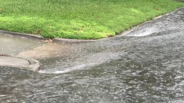 Flooding on a suburban street in the midwest - Heavy thunderstorms create flood conditions in a neighborhood area. Rainwater and runoff flowing in the suburbs