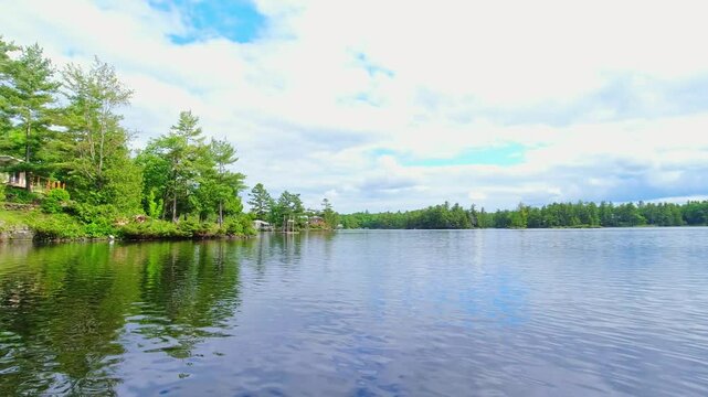 POV from the small boat boating through freshwater lake between spruce fir trees islands and vegetation. View for the boat front trolling moving during fishing. Beautiful North American dream view.
