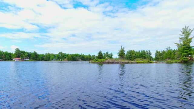 POV from the small boat boating through freshwater lake between spruce fir trees islands and vegetation. View for the boat front trolling moving during fishing. Beautiful North American dream view.