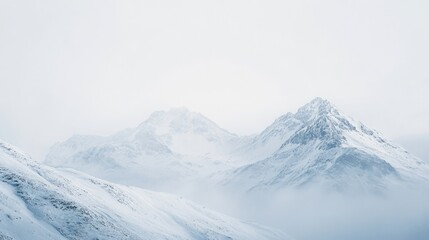Obraz premium Snow-covered mountain range under a pale winter sky, tranquil and serene alpine landscape scene