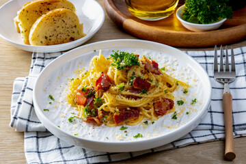 Spaghetti Carbonara in a white plate on wooden table background