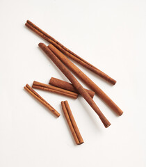 Scattered Cinnamon Sticks on the Floor isoalted ob white background: A Rustic Display. Top view