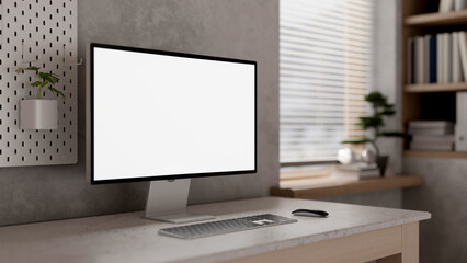 Fototapeta premium A computer mockup on a table against the cement wall in a modern loft home office.