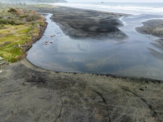 Estuary flowing into the ocean at Muriwai, Auckland, New Zealand.