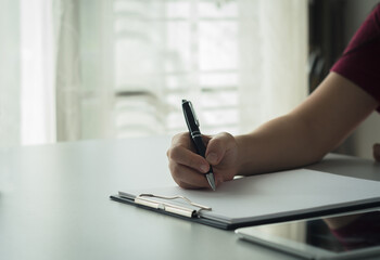 Person  working  writing in notebook with pen at table Business planning, work recording, financial recording, working with documents