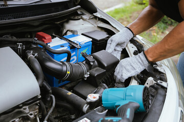 A technician in a workshop uses a wireless device to check a car's condition, updating a digital certificate. The scene highlights automotive repair, service, and efficiency in maintenance.