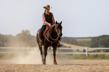 Western riding concept: A young woman and her black quarter horse stallion doing some reining...