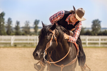 Western riding concept: A young woman and her black quarter horse stallion doing some reining...
