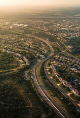 Obraz premium An aerial view of a city with winding roads and houses. AI.