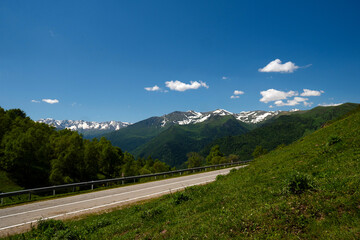 Naklejka premium Mountain road with snow-capped mountains