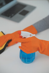 Woman cleaning table using rag and diffuser at home.