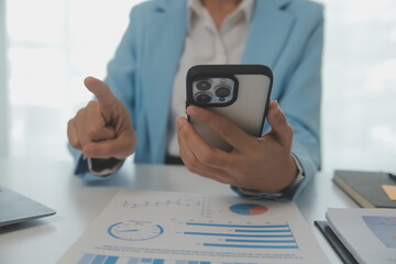 Portrait of a happy Asian businesswoman using mobile phone indoor, Asian businesswoman working in modern office.