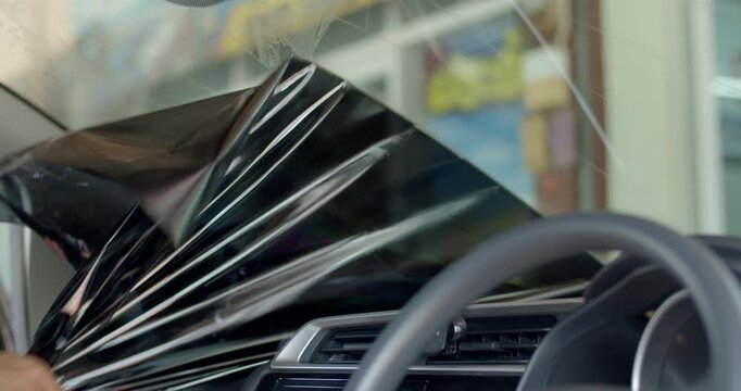 Peel off car window film.Change out the old car film.Car tint technicians are replacing the film with a new one that better protects against UV light.