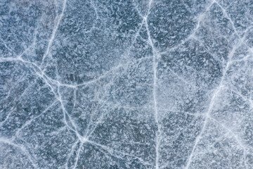 Aerial shot of grid-like patterns on dark blue frozen lake