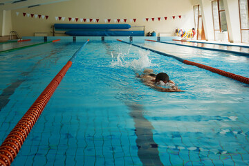 A swimmer trains for a competition in an indoor swimming pool