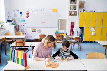 Teacher using geoboard in class, teaching students, explaining geometry, shapes, fractions or...