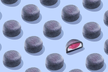 Food Pattern, Mochi - Japanese dessert, sweets. From rice dough. A black Mochi with red berry filling Isolated on a blue Background