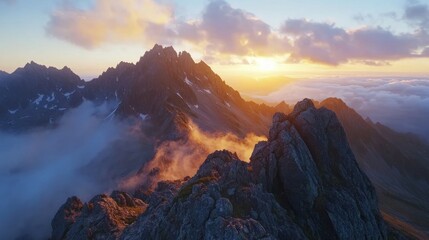 Early morning in High Tatras mountains, Slovakia. An amazing view of high rocky peaks surrounded by clouds during golden hour. Sunrise over High Tatras mountains from the top of Koprovsky peak