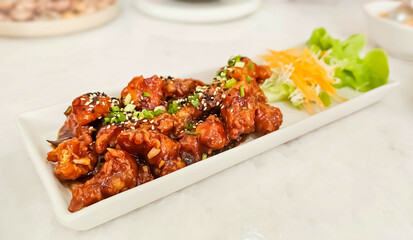Korean fried chicken crispy crunchy on plate. Yangnyeom chicken is a variety of Korean fried chicken seasoned with a sweet and spicy sauce of gochujang.