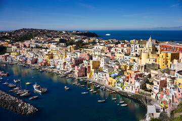 Beautiful panoramic view of Procida, Italian Capital of Culture 2022. Harbour of Corricella, Campania region, Italy, Europe with colorful houses, cafes and restaurants, fishing boats and yachts.
