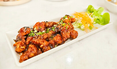 Korean fried chicken crispy crunchy on plate. Yangnyeom chicken is a variety of Korean fried chicken seasoned with a sweet and spicy sauce of gochujang.