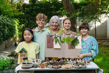 Portrait of students and female teacher at outdoor sustainable education class. Learning about nature, plants. Concept of experiential learning and ecoliteracy.