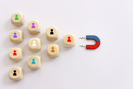 Concept image of a magnet attracting a group of people. metaphor of media influence and human resources