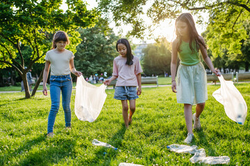 Fototapeta premium Students on nature walk picking plastic litter, environmental cleanup during outdoor sustainable education class. Concept of experiential learning and ecoliteracy.