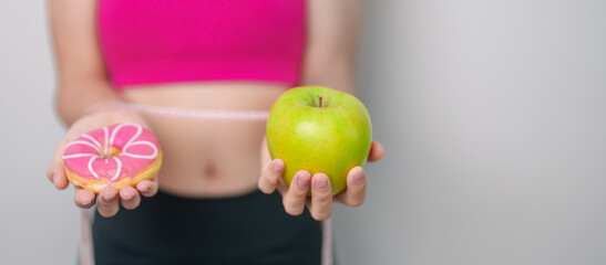 woman hand hold green Apple and donut, female fitness choose between fruit is Healthy and sweet is...