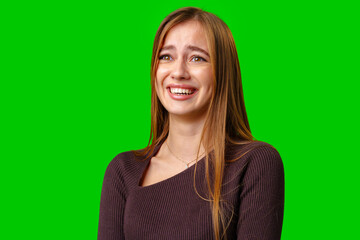 Fototapeta premium Young Woman With Long Brown Hair Laughing in Front of Green Screen