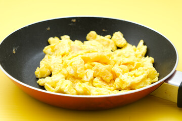 scrambled eggs on frying fan served for breakfast