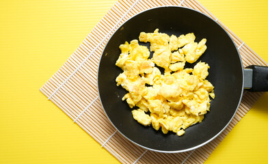 scrambled eggs on frying fan served for breakfast