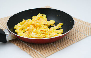 scrambled eggs on frying fan served for breakfast