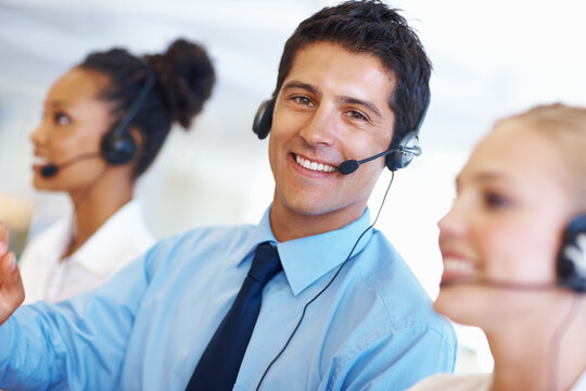 Man, portrait and happy in call center for customer service, telemarketing and FAQ in office. Male consultant, smile and headset at help desk with team, communication or bilingual agent with tech