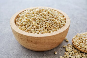 Barley rice in a wooden cup on gray cement background