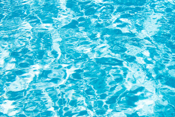 Blue pool water background. Blurred transparent clear calm water surface texture. Water waves in sunlight with copy space.