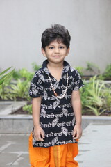 cute little indian boy is dressed up like lord Krishna with Radha name written in Hindi language on...