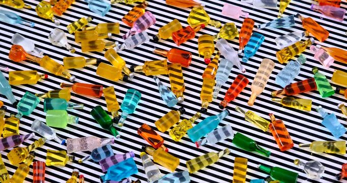 various miniature bottles of alcohol without labels in motion on a rotating table with hypnotic black and white lines stripe pattern