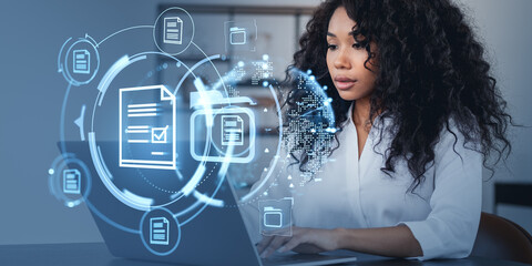 Woman working on laptop with digital document icons around her.