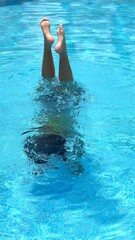 Young girl performing one of her first underwater exercises in swimming pool Scene captures initial...