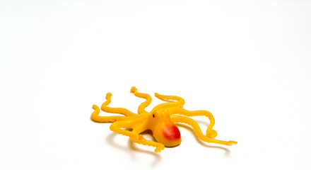 Children's Toy In The Form Of Yellow Octopus Animal With Isolated White Background And Photographed Using The Rule Of Thirds Photo Composition