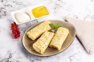 Homemade stuffed pancakes with honey and cream sour